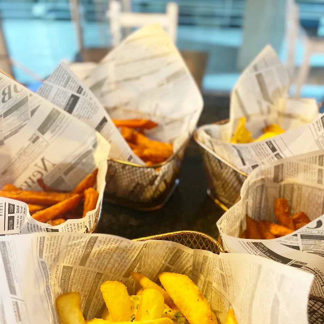 Batatas fritas douradas em cesto de papel